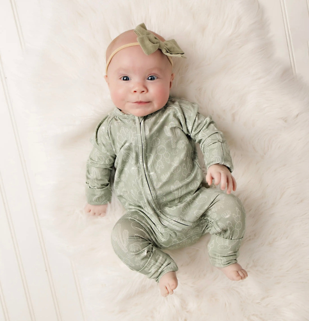 baby girl wearing baby bamboo pajama romper in sage with a cactus print