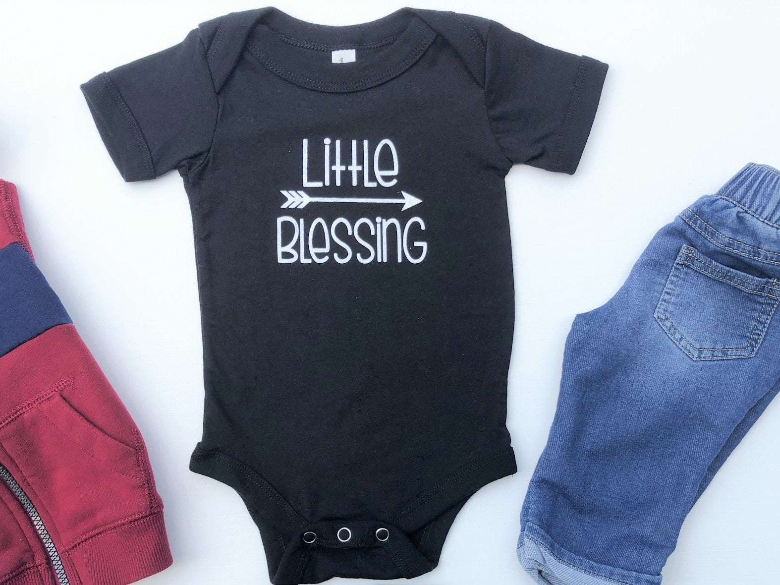 Black baby bodysuit with the text Little Blessing