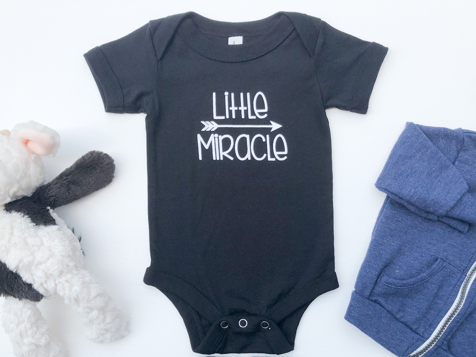 Black baby bodysuit with the text Little Miracle