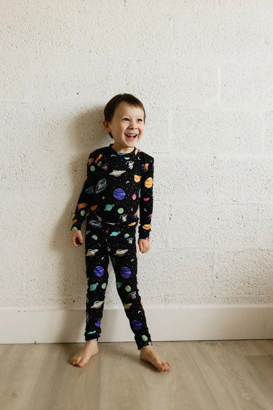toddler boy wearing toddler bamboo pajama set with outer space print