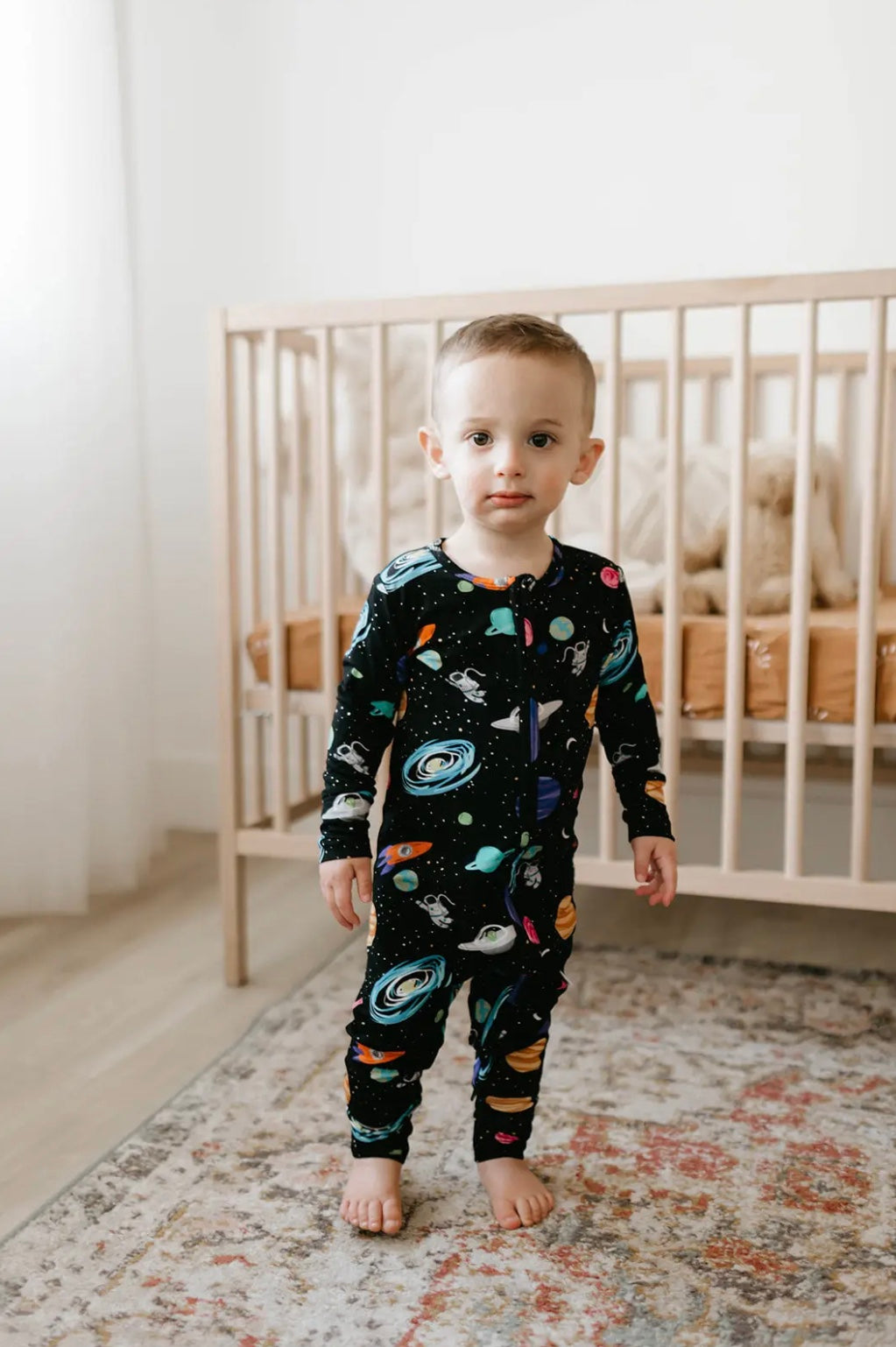 baby boy wearing baby bamboo pajamas romper in black with outer space print