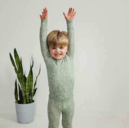 toddler boy wearing sage colored bamboo pajama set with cactus print