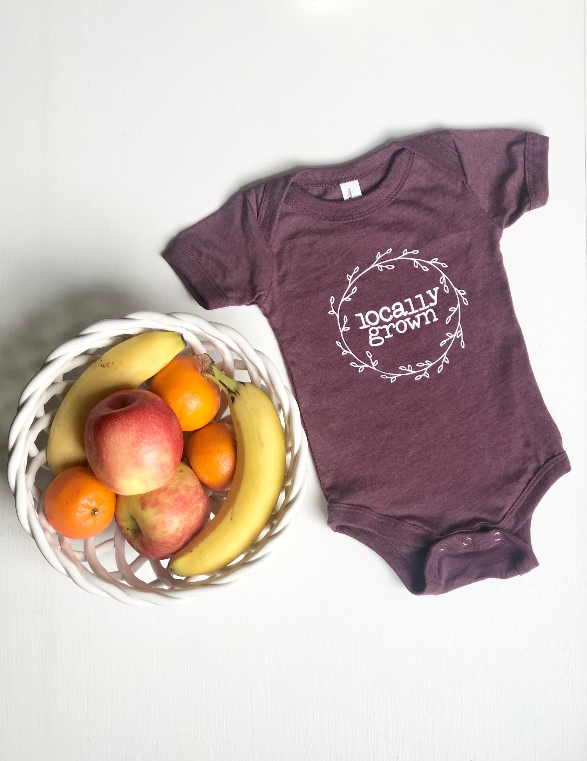 Purple baby bodysuit with the text Locally Grown