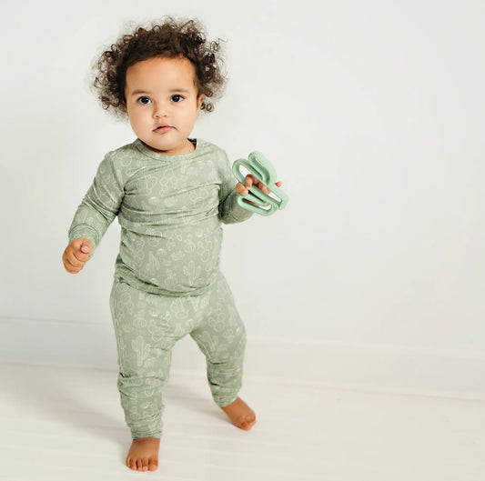toddler girl wearing sage colored bamboo pajama set with cactus print