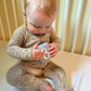baby boy wearing taupe woodland print baby bamboo pajamas romper