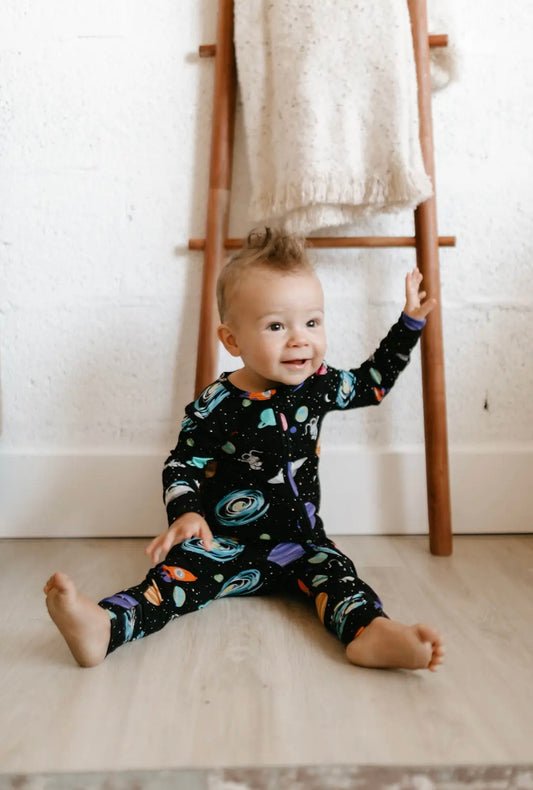 baby boy wearing baby bamboo pajamas romper in black with outer space print